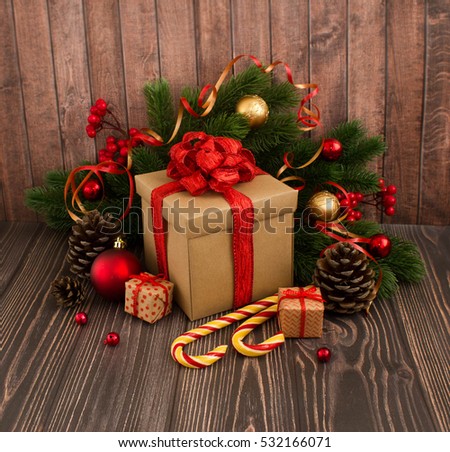 Christmas or New Year background: gifts, red glass balls, decoration and candle on wooden background