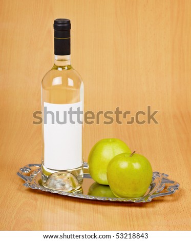 Apple wine in the closed bottle on a metal tray