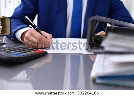 Close up view of bookkeeper or financial inspector hands making report, calculating or checking balance. Internal Revenue Service inspector checking financial document. 
