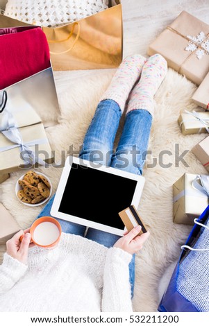 Christmas online shopping top view. Female buyer with credit card upon empty screen of tablet, copy space. Woman buys presents, prepare to xmas, near gift boxes and packages. Winter holiday sales