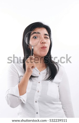 Photo image portrait of a successful young beautiful Asian businesswoman smiling while seriously looking into magnifying glass, close up portrait over white background