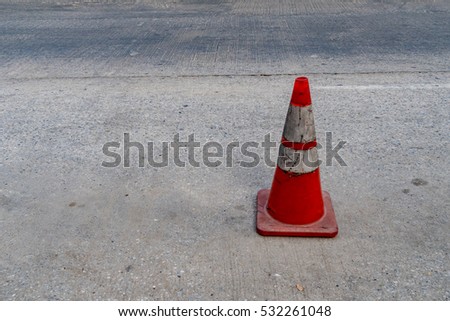 Plastic orange cone on concrete road