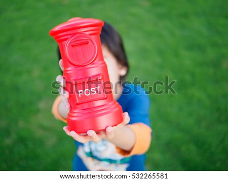 soft focus of abstract money saving asian boy hands are holding piggy bank or POST saving bank with green grass background