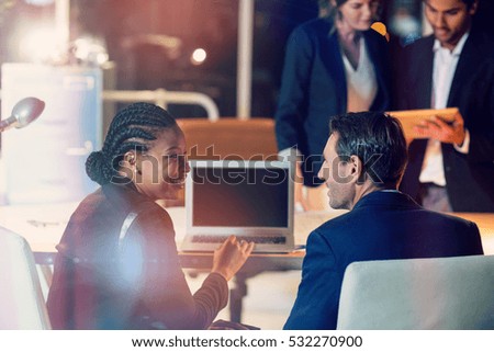 3D Businesspeople discussing over laptop and digital tablet in office