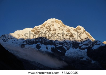 Sunrise on Annapurna 1 with the after-mist of an avalanche, photo taken from Annapurna Base Camp in the Himalayas.