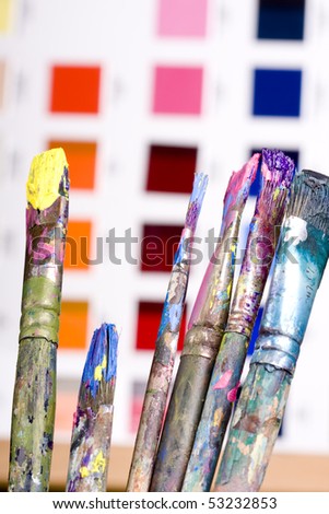 Artistic equipment: paint, brushes and knives on paint background