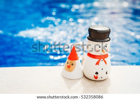 Wooden christmas decoration, blue background, suitable for new year greeting cards, tropical x-mas, snowman and santa