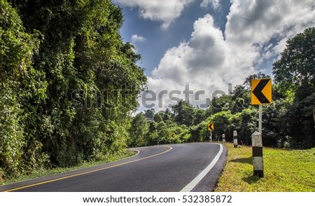 The road curved left and turn left signs direction in countryside.