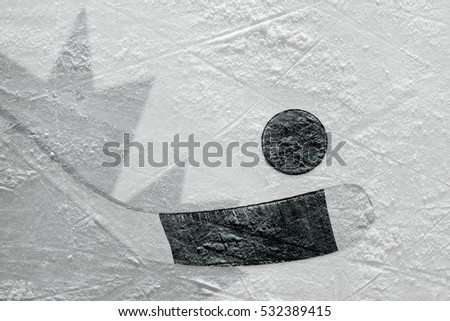 Hockey puck, stick, and the image of the Canadian flag on the ice. Concept