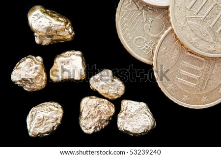 Gold nuggets and money, euro coins on a black background. closeup.