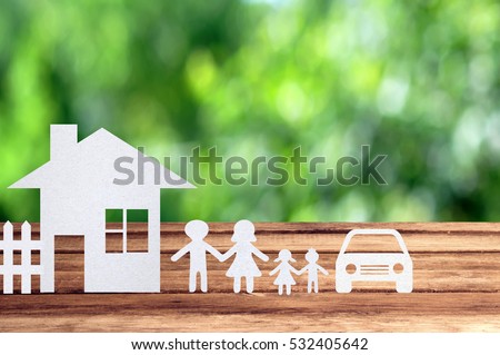 Paper family, house and car on wooden table with garden bokeh outdoor theme background