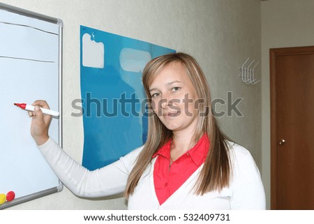 The young woman with a marker standing at a board