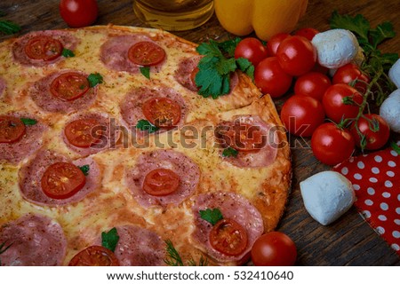 Pizza and different ingredients in it. Dark background. View from above. Studio photography, Subject photography.