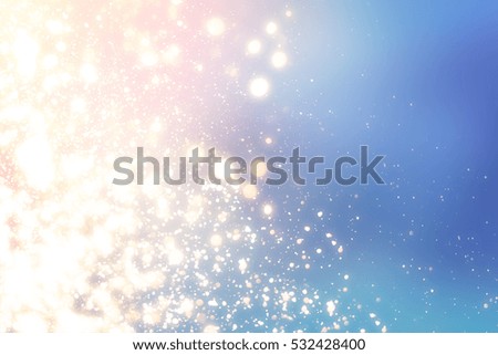 Christmas abstract bokeh glitter lights on blue background. Round defocused circle particles