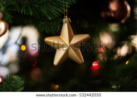 Christmas holiday golden star hanging from the pine tree