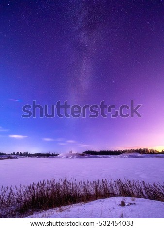 Beautiful starry over a frozen lake milky Milky Way during winter. Astro photography.
