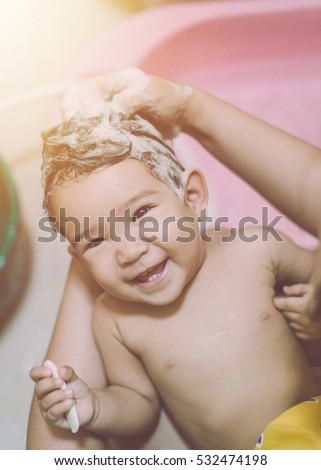 Artificial grain added style picture, Happy baby taking a bath playing with shower head, Parent and kid play with water, Young child in a bathtub, Smiling kids in bathroom, Mom bathing infant
