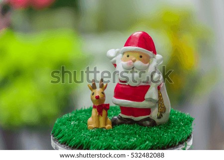 Santa Claus doll and his reindeer with blur background in Christmas  festival.