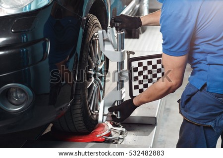 Grid sensor sets mechanic on auto. Car stand with sensors wheels for alignment camber check in workshop of Service station. Royalty-Free Stock Photo #532482883
