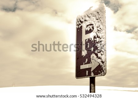 parking sign with blue sky and clouds and snow
