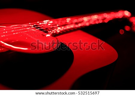 Acoustic guitar in red light at night