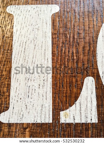 Wooden alphabet letter L. Written letter with paint on a wooden background. Alphabet wood texture.