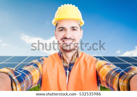 Confident engineer taking a self portrait with ecologic panels in background