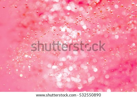 Drops in a jet of water on a red background 