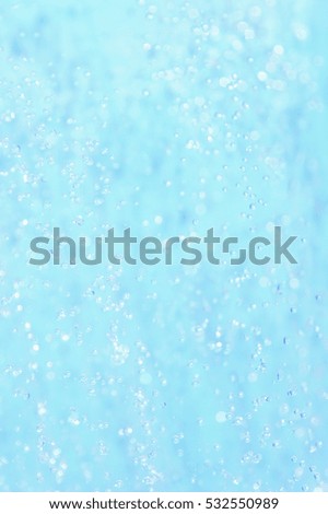 Drops in a jet of water on a blue background 