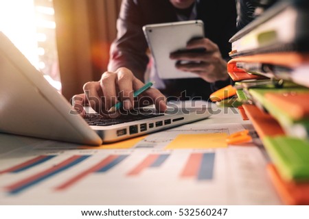 business documents on office table with smart phone and digital tablet and graph business with social network diagram and man working in the office Royalty-Free Stock Photo #532560247