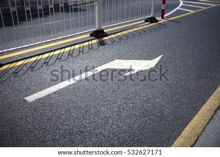 Arrow sign on asphalt indicatng a turn