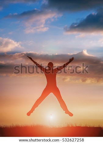 Silhouette of a woman jumping at the sunset background