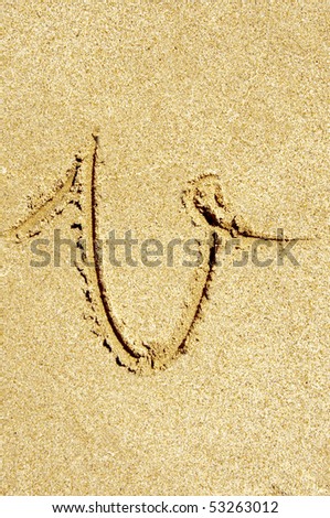 v letter written in the sand on a beach