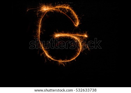 The English letter G made of sparklers on black background