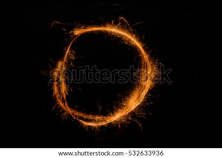 The English letter O made of sparklers on black background