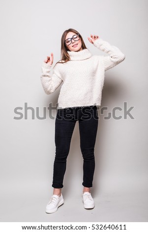 Young woman in sweater in studio. looking away. isolated gray background