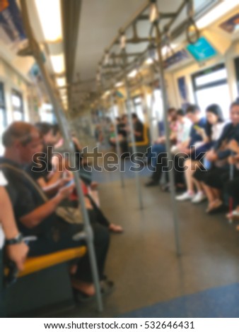 Blurred people are sitting and play smartphone in train in downtown Bangkok. Blurred picture.