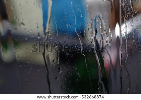 Rain drop on the glass window in Rainy season and blur light 
