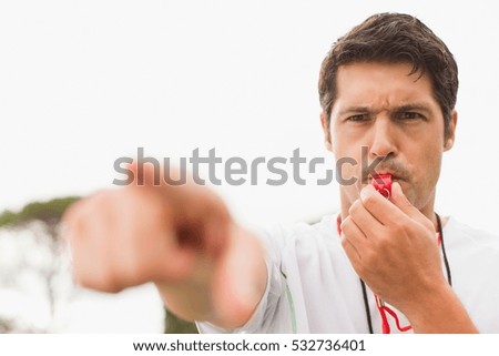 Referee blowing whistle in game