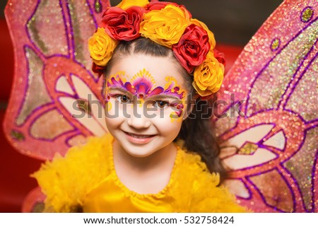 child with fairy wings in yellow shirt Royalty-Free Stock Photo #532758424
