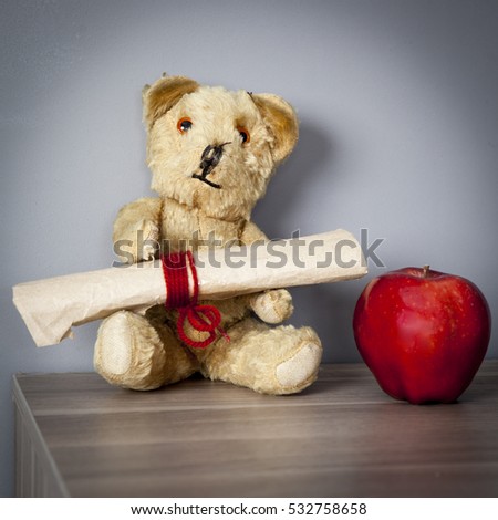 Old vintage teddy-bear with apple sitting on the capboard