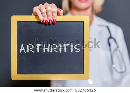 Arthritis Chalkboard Sign Held By Female Doctor In Dark Room.