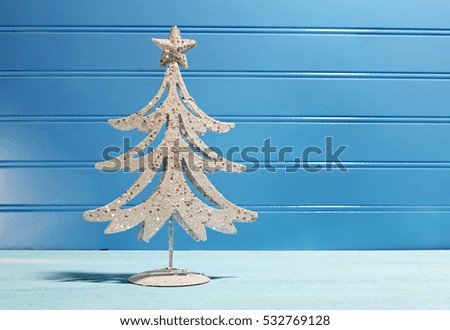 A decorative Christmas tree on a wooden blue background with copy space