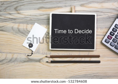 sentence time to decide written with chalk on a blackboard, on a wooden table with pen