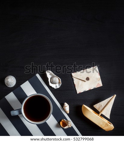 coffee cup on striped napkin, seashells and boat
