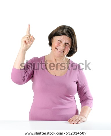 Cute elderly woman with a raised index finger (a gesture of "attention"). Studio photography on a white background. 
