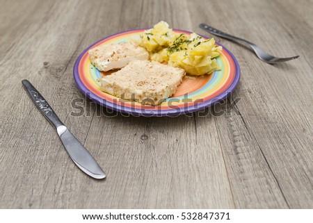 Knife and fork next to a plate with food