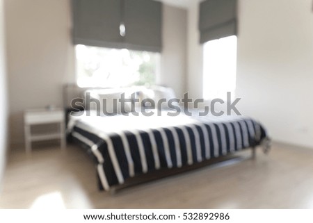 Blurred bedroom with white and black bed