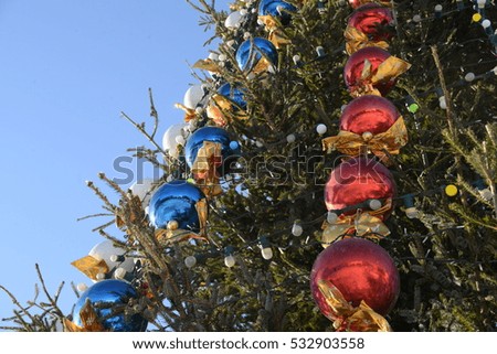 the New Year tree on the city square is decorated with beautiful spheres and garlands and Christmas tree decorations all sparkles betrays magic mood of a holiday