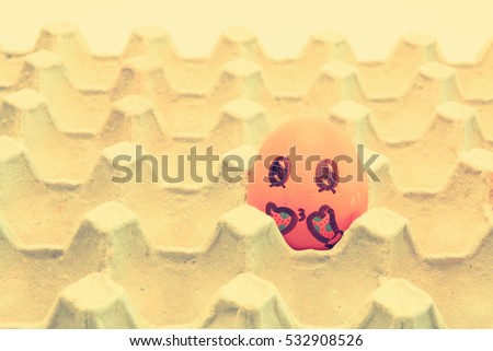 Brown chicken egg with gloves arranged in carton